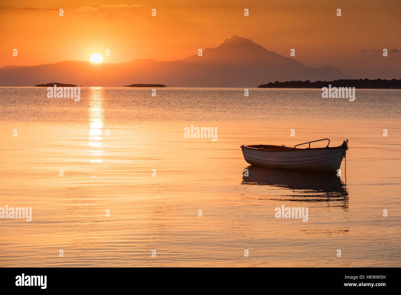 Piccola barca da pesca nella calma baia greca di sunrise Foto Stock