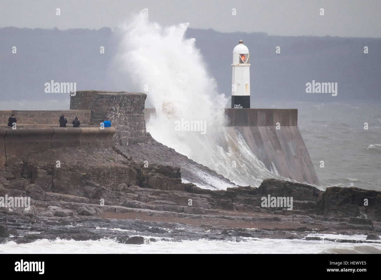 Onde infrangersi contro la parete del porto in Porthcawl, nel Galles del Sud durante la tempesta Barbara. Un avviso meteo per tutto il Galles è stato rilasciato per il mezzogiorno con forti venti e piogge previsto. Foto Stock