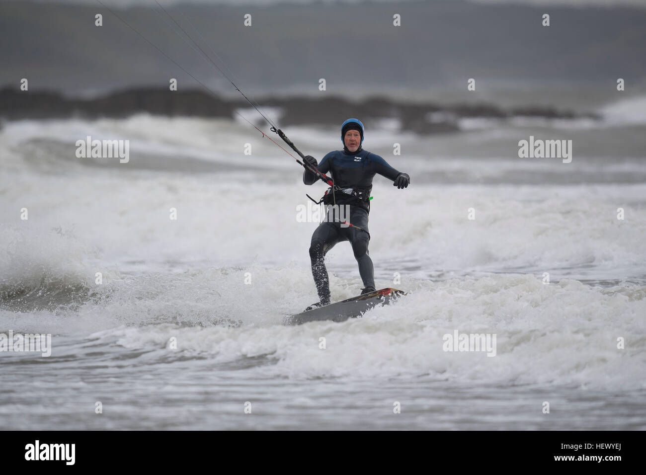 Kite surfers a Porthcawl, nel Galles del Sud durante la tempesta Barbara. Un avviso meteo per tutto il Galles è stato rilasciato per il mezzogiorno con forti venti e piogge previsto. Foto Stock
