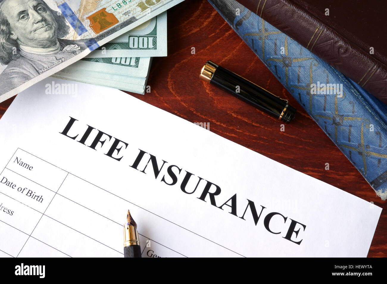 Polizza di assicurazione vita e moneta su un tavolo. Foto Stock