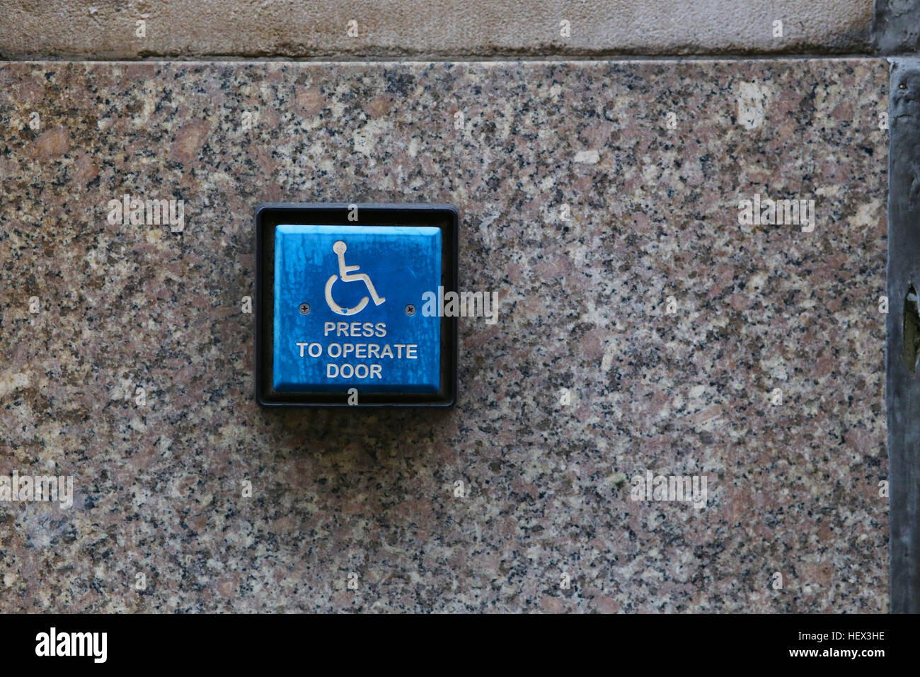 Sedia a rotelle porta il pulsante assist su una parete Foto Stock