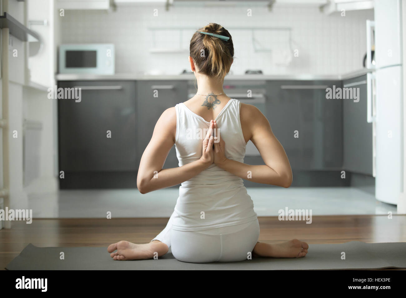 Donna seduta in posa Gomukasana Foto Stock