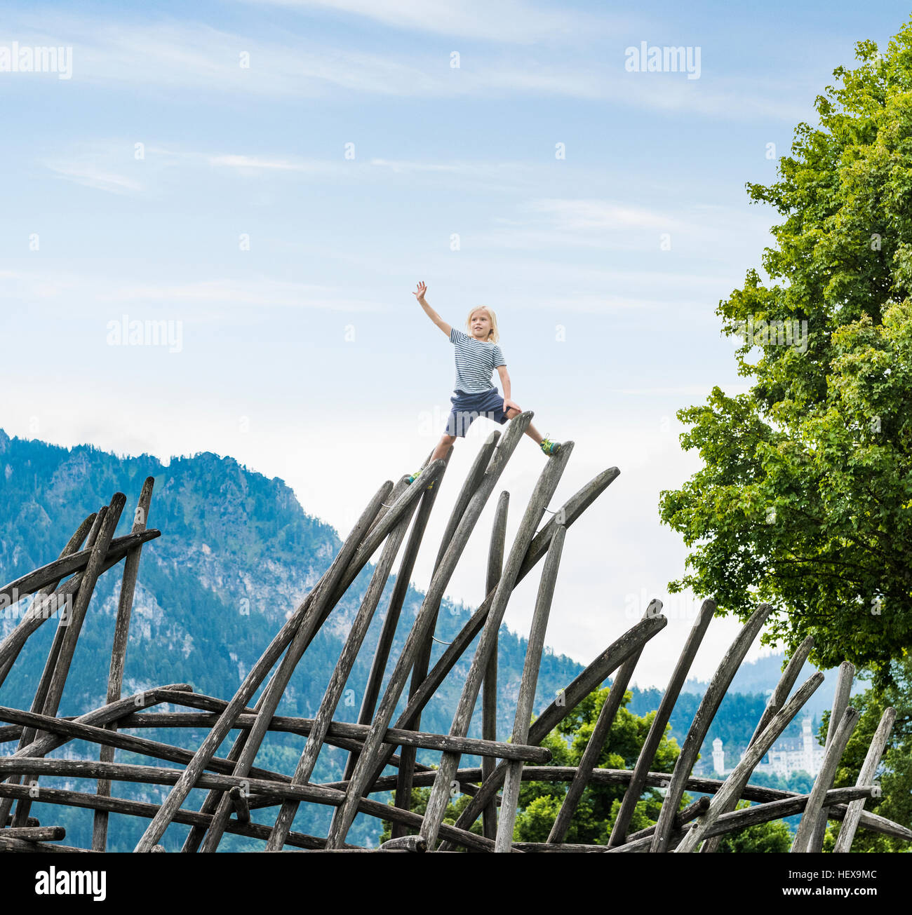Ragazzo in piedi sulla parte superiore della struttura in legno nel parco giochi, Fuessen, Baviera, Germania Foto Stock