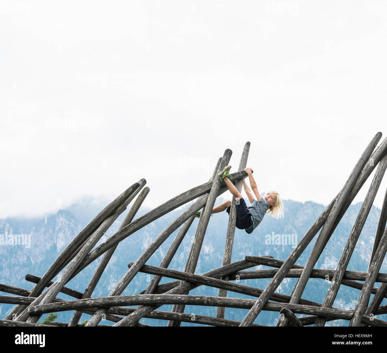 Ragazzo arrampicata su struttura in legno nel parco giochi, Fuessen, Baviera, Germania Foto Stock