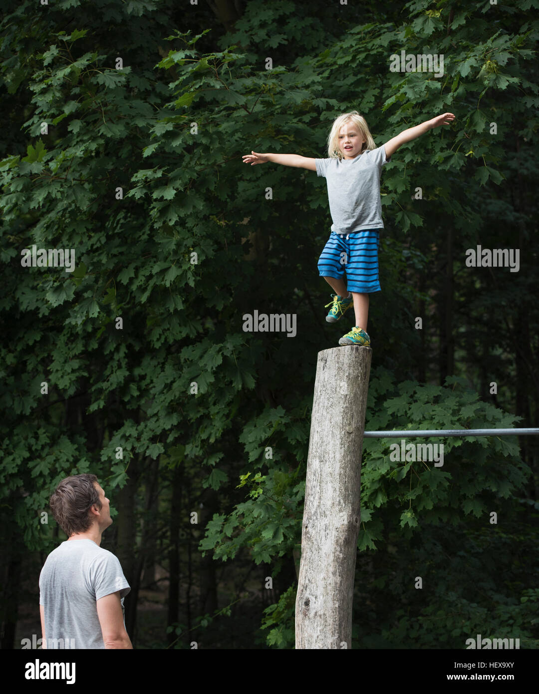 Ragazzo su una gamba, bracci aperti, bilanciamento in pole Foto Stock