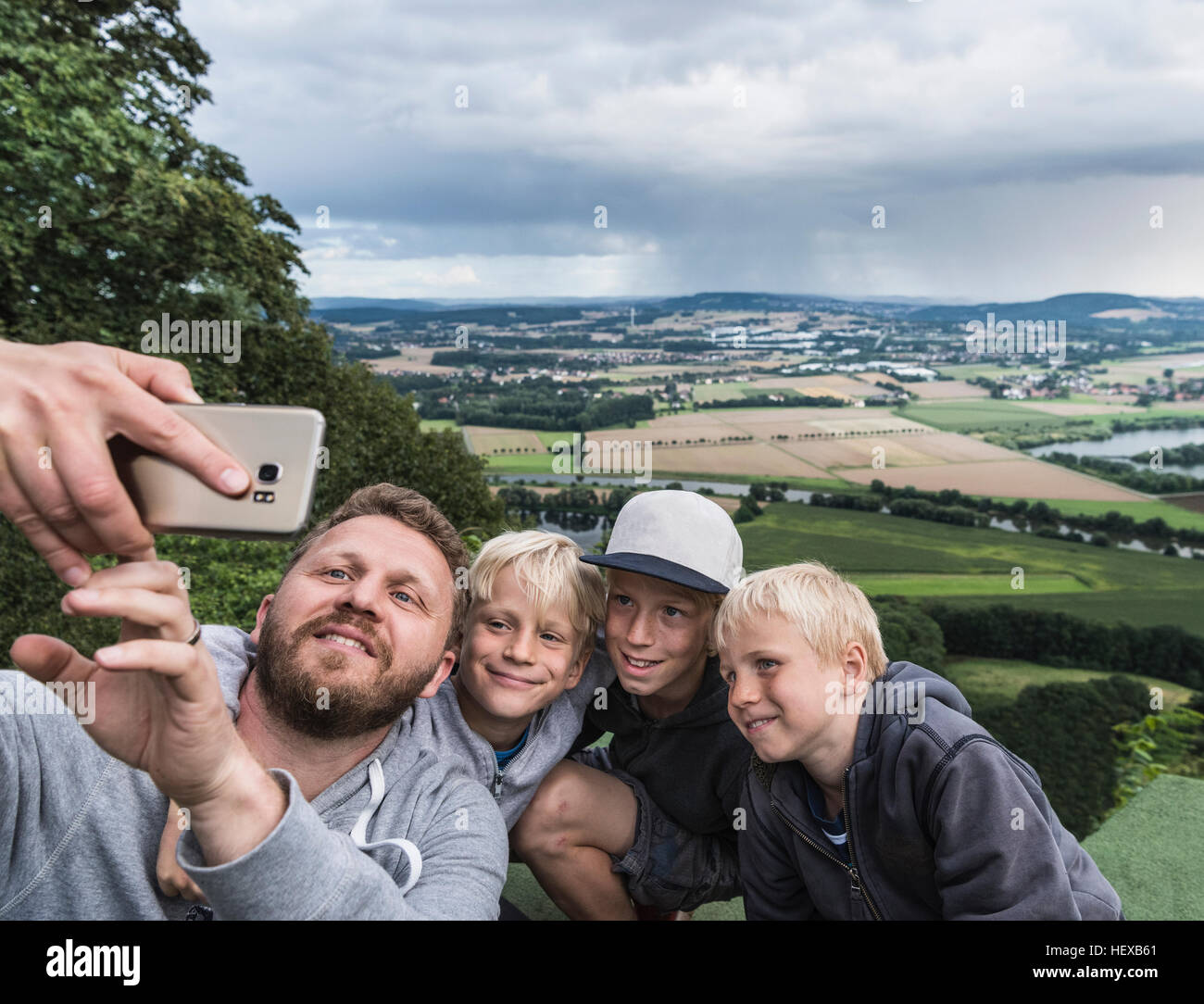 Padre e figli tenendo selfie Foto Stock