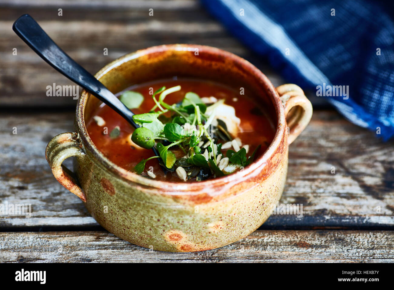 Ciotola di zuppa guarnita con crescione, sul tavolo di legno Foto Stock