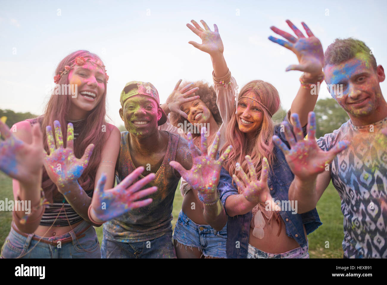 Ritratto di gruppo di amici al festival, coperto di polvere colorata vernice Foto Stock