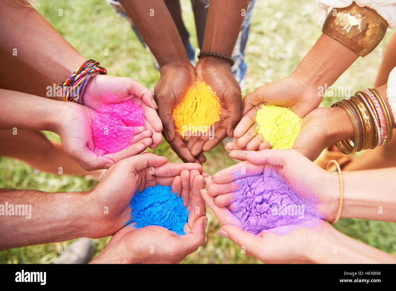 Gruppo di amici al festival, tenendo colorati di vernice in polvere in mani a tazza, close-up Foto Stock