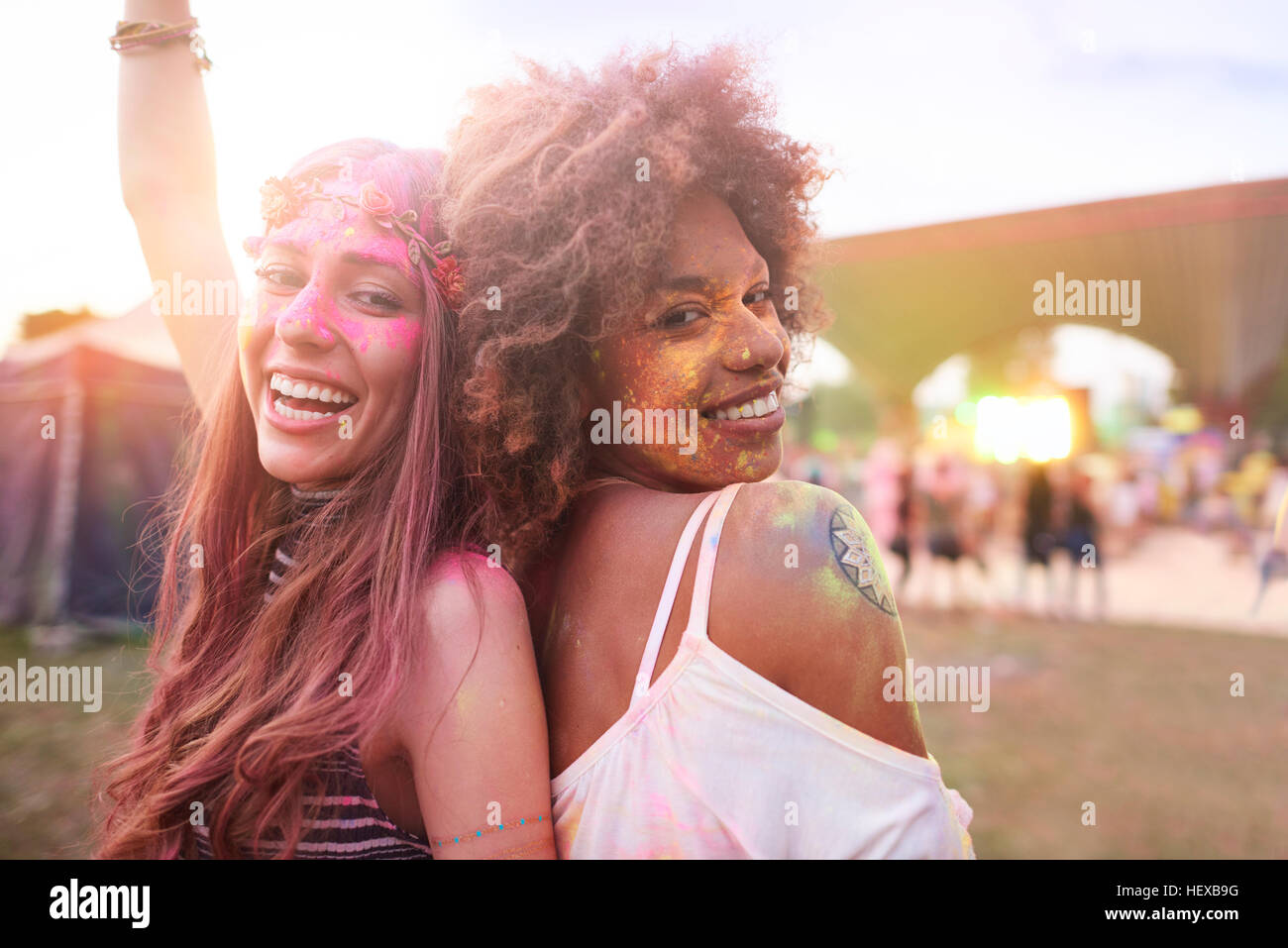 Ritratto di due amici di sesso femminile al festival, coperto di polvere colorata vernice Foto Stock