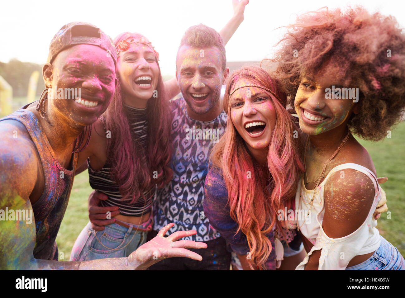 Ritratto di gruppo di amici al festival, coperto di polvere colorata vernice Foto Stock