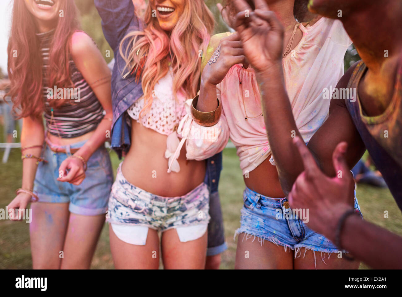 Gruppo di amici al festival, coperto di polvere colorata vernice, metà sezione Foto Stock