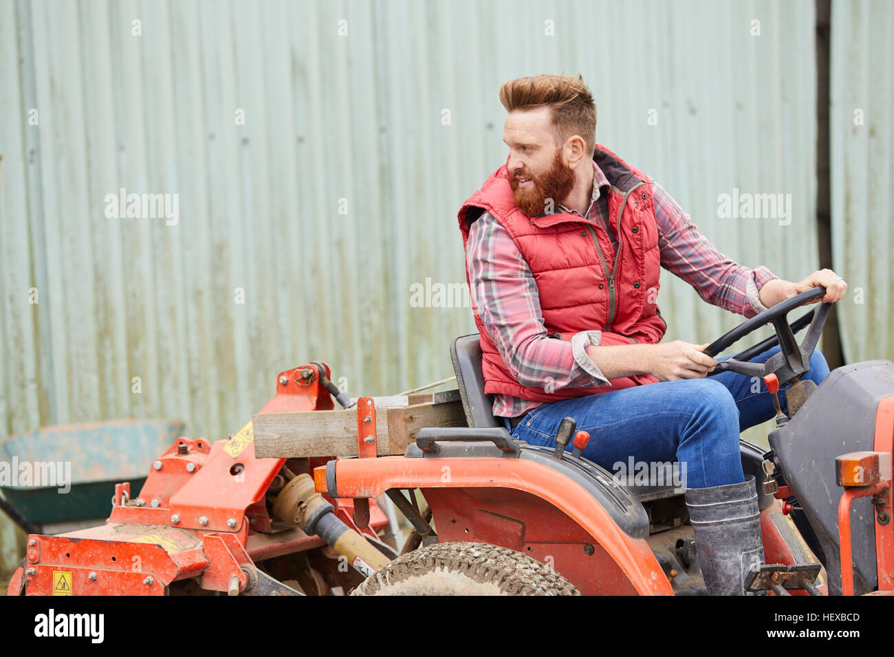 Uomo su una farm di guidare il trattore Foto Stock