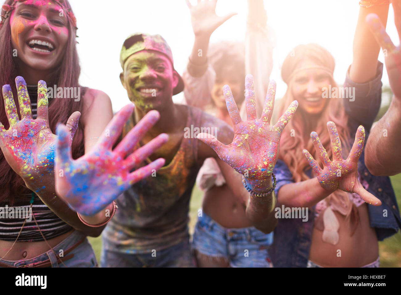 Ritratto di gruppo di amici al festival, coperto di polvere colorata vernice Foto Stock