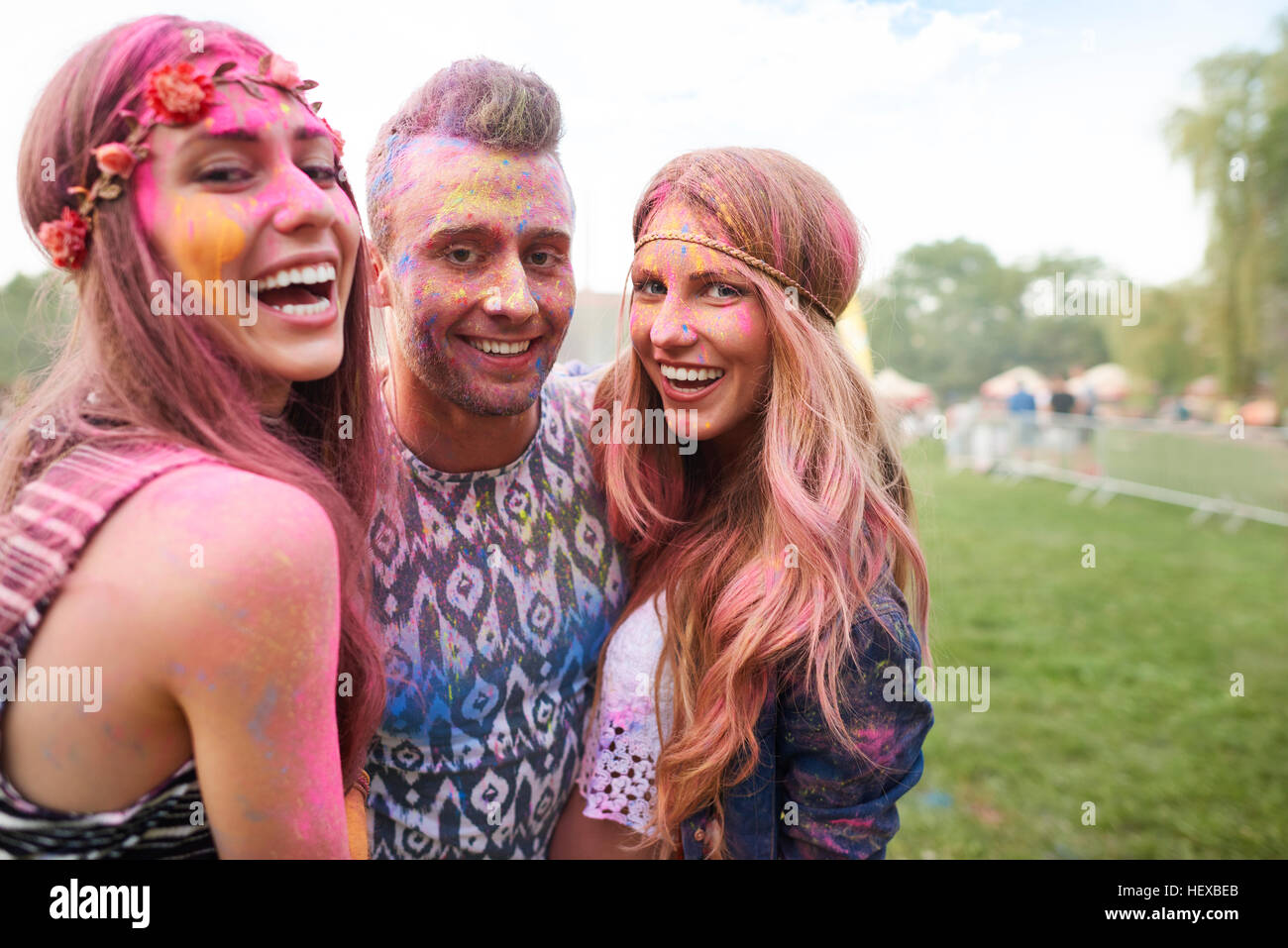 Gruppo di amici al festival, coperto di polvere colorata vernice Foto Stock