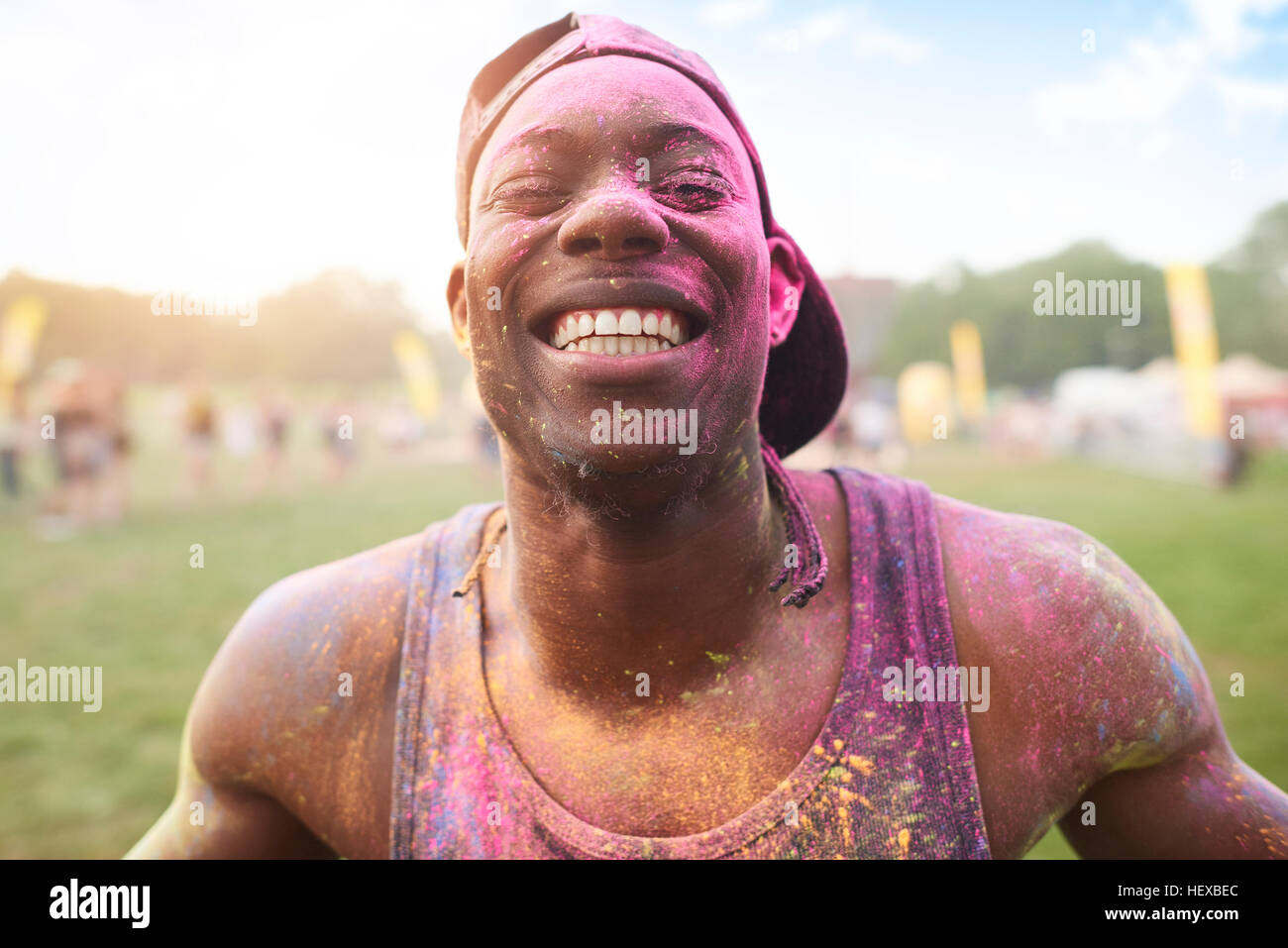 Ritratto di giovane uomo al festival, coperto di polvere colorata vernice Foto Stock