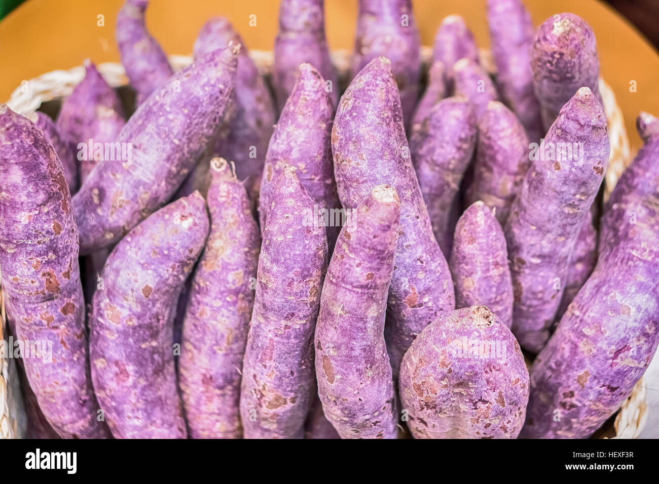Viola la patata dolce su sfondo di legno. Foto Stock
