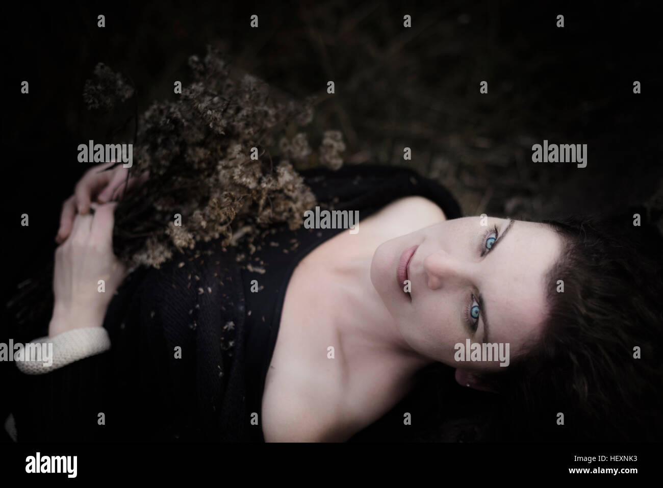Ritratto di donna malinconico giacente sul suolo della foresta Foto Stock