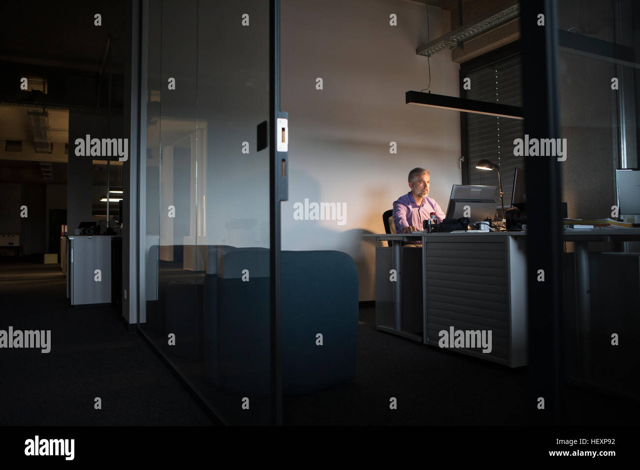 Imprenditore lavora fino a tardi in ufficio Foto Stock