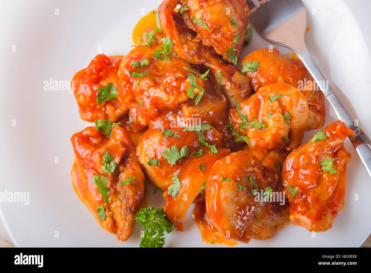 Disossati cosce di pollo con sweet chill e salsa di erbe su piastra Foto Stock