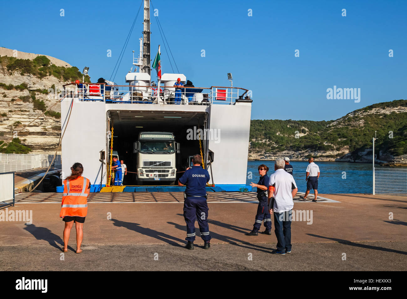 Bonifacio, Francia - luglio 3, 2015: Cargo carrello lascia fuori il traghetto nel porto di Bonifacio, piccolo porto di Corsica nella soleggiata giornata estiva, persone da Foto Stock
