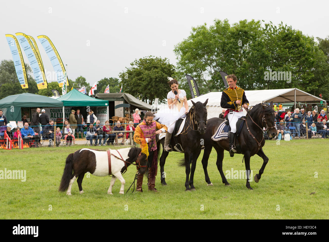 Un uomo e una donna in costume corsa dei cavalli in un evento espositivo in tre contee show, Malvern, Worcestershire, Inghilterra Foto Stock