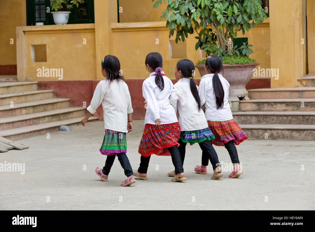 Quattro ragazze passeggiate all' unisono in tutta la scuola cantiere. Foto Stock
