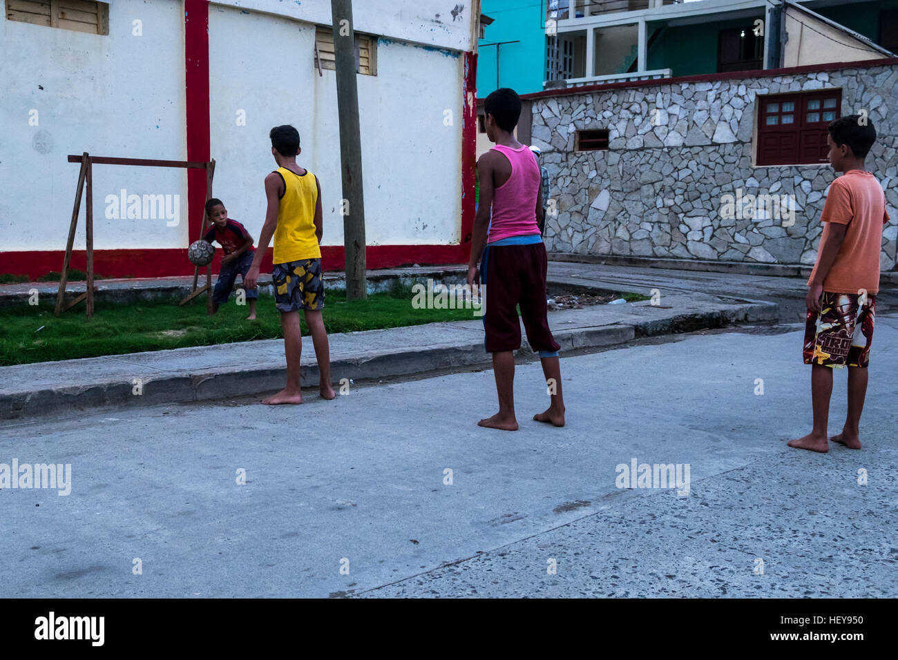 Ragazzi che giocano a calcio a piedi nudi in strada, Baracoa, Cuba Foto Stock