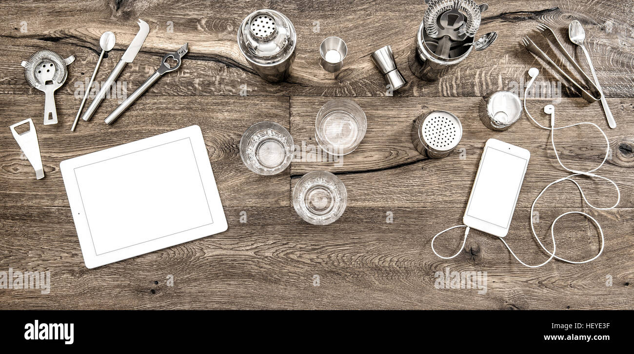 Banco Bar con strumenti, accessori e dispositivi elettronici. Bicchieri sul tavolo di legno sfondo Foto Stock