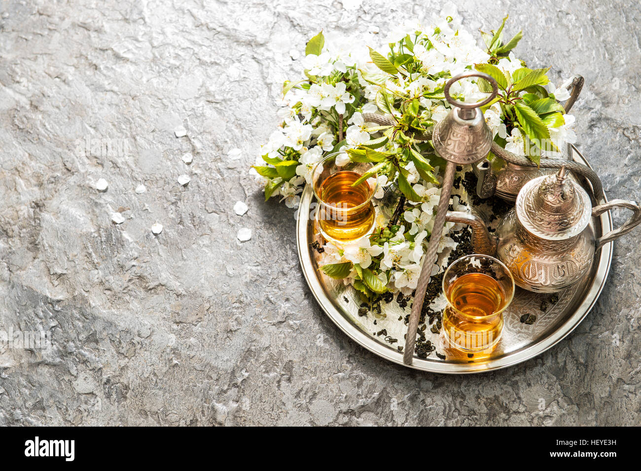 Bicchieri di tè e pot. Oriental vasellame in argento. Fiori di Primavera decorazione. Messa a fuoco selettiva Foto Stock
