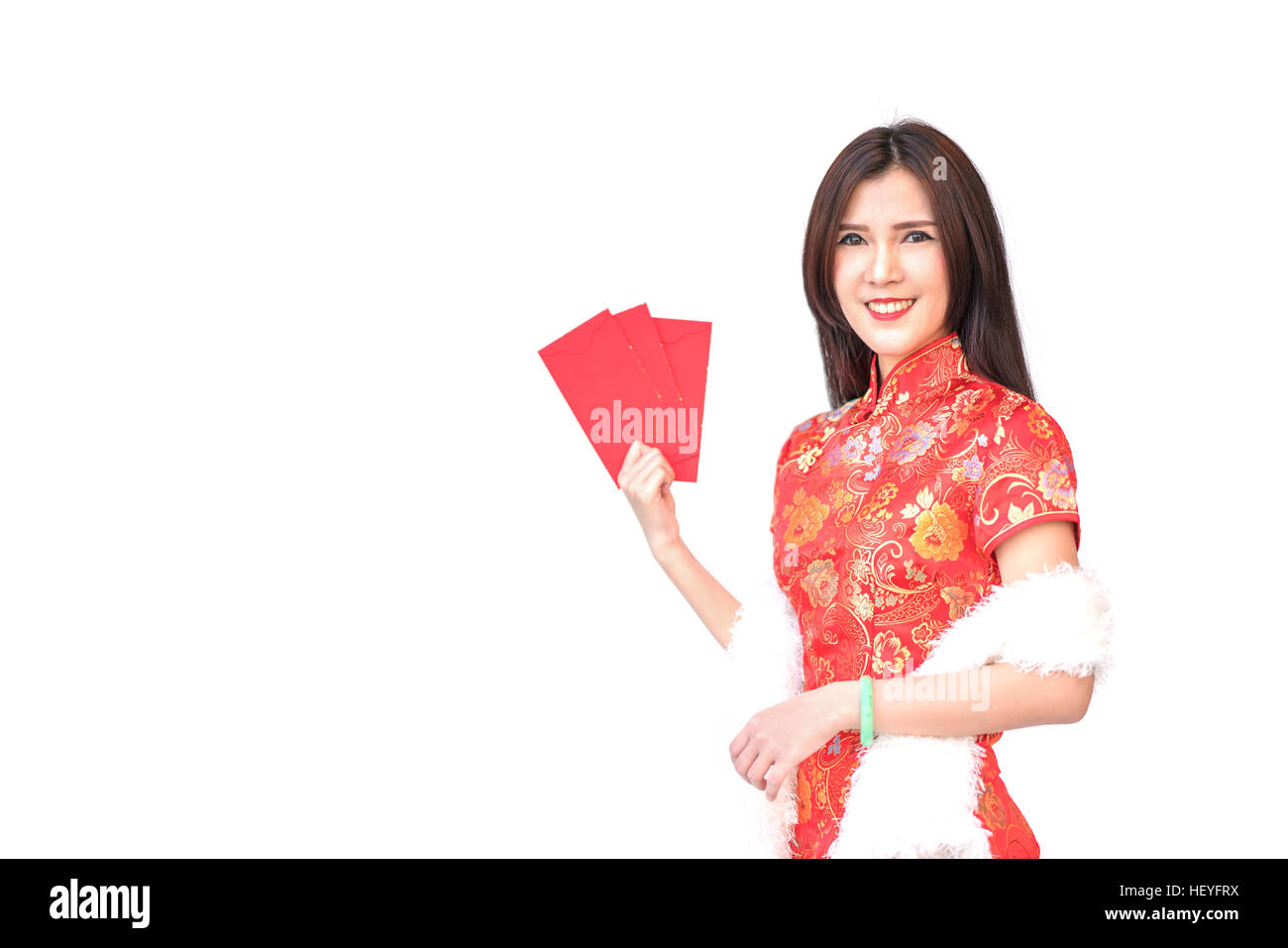 Bella ragazza asiatica in cinese qipao abito tradizionale, tenendo rosso tasche di denaro o il biglietto di auguri buste, nuovo anno cinese concetto, isolati su w Foto Stock