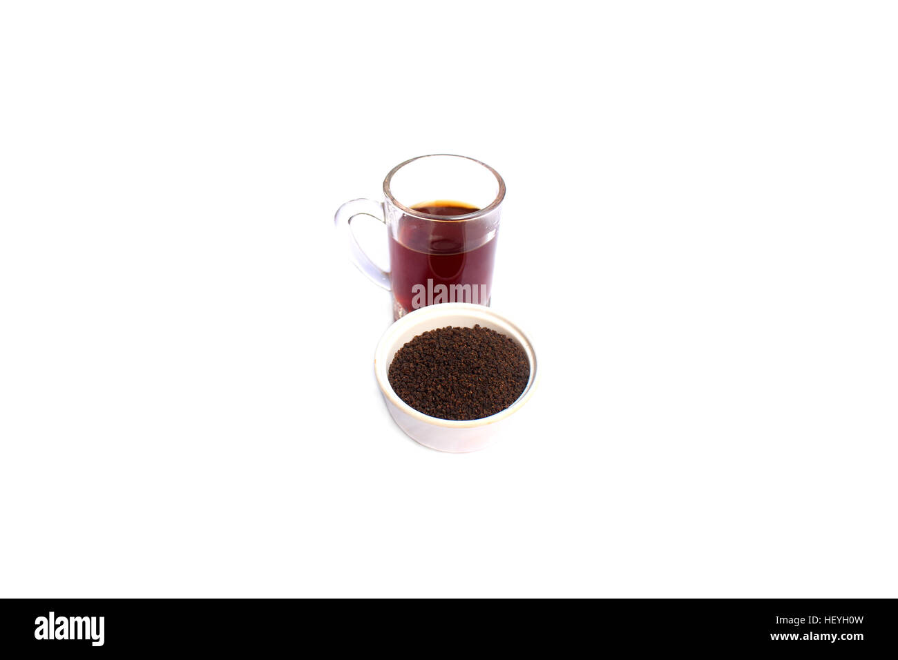 Il tè in polvere in un recipiente con una tazza di tè su sfondo bianco Foto Stock