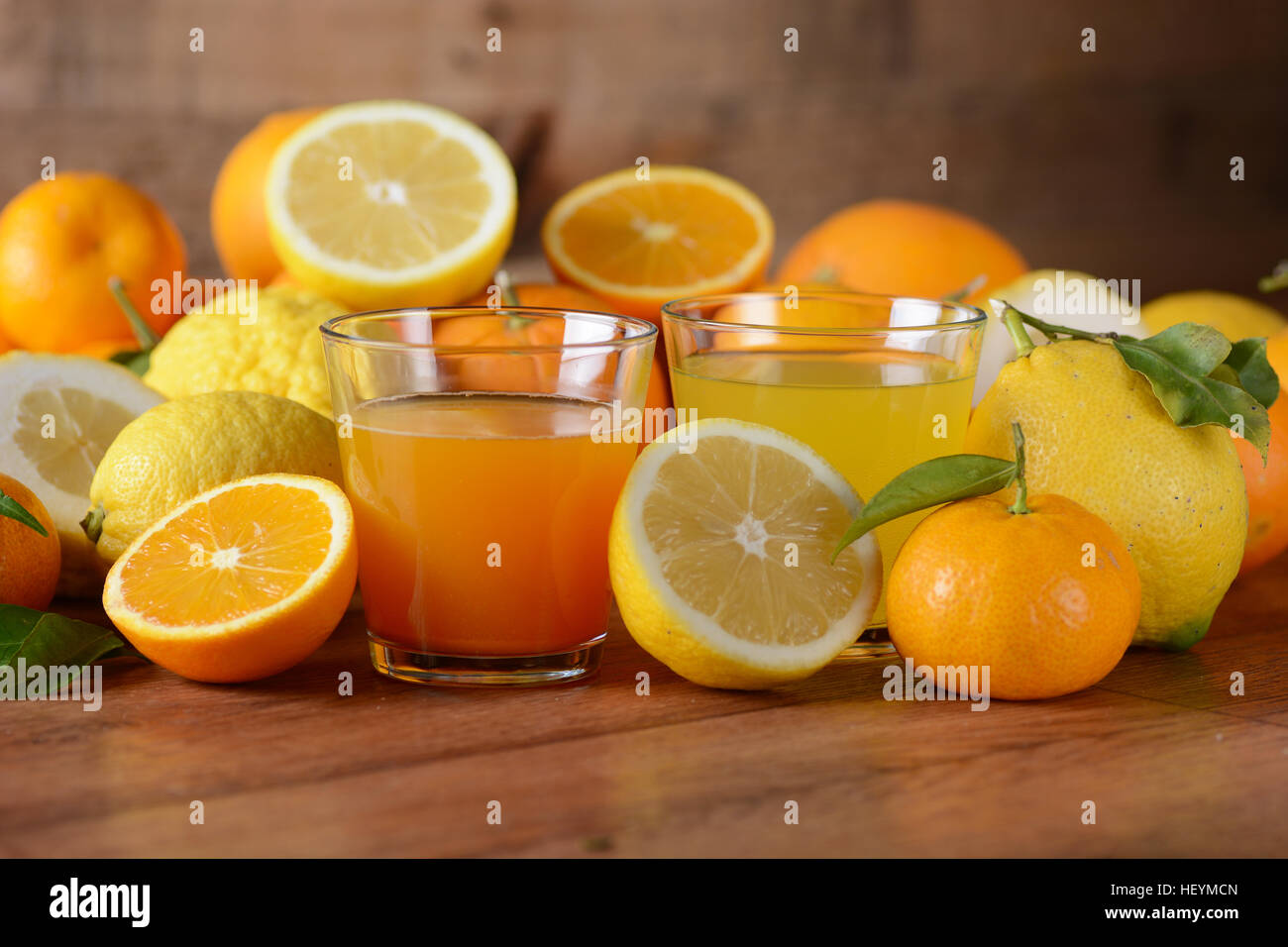 Succhi di agrumi sul tavolo con frutti intorno Foto Stock