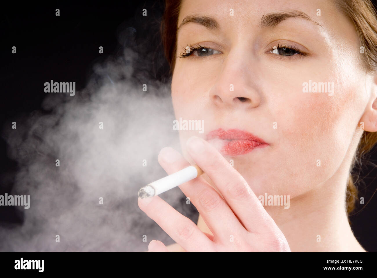 Giovane donna di fumare una sigaretta Foto Stock
