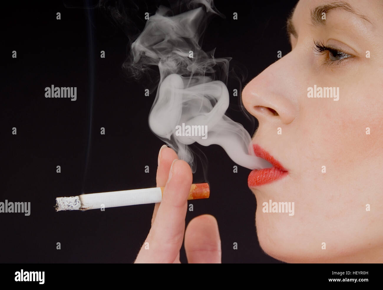 Giovane donna di fumare una sigaretta Foto Stock