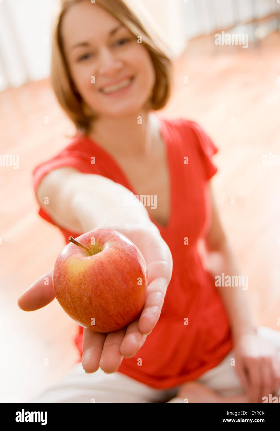 Giovane donna che offre un apple Foto Stock