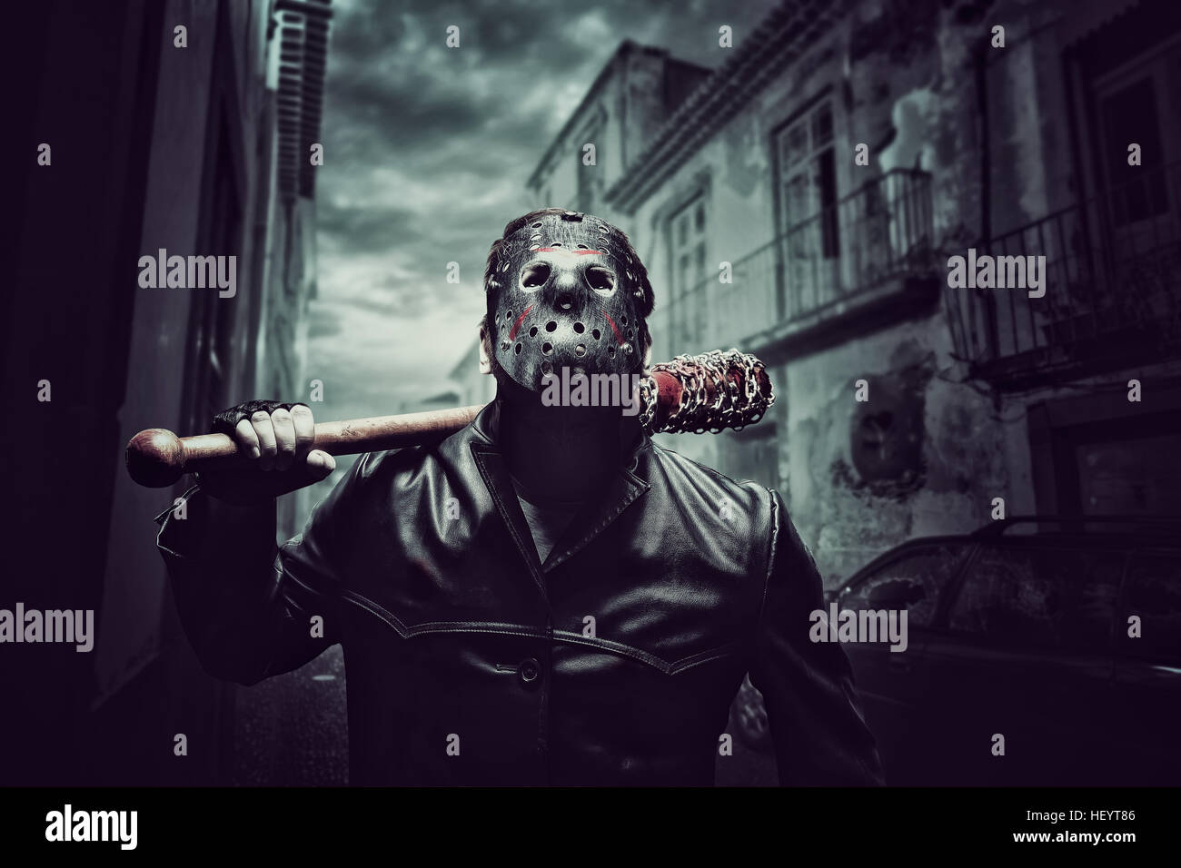 Psico uomo nella maschera di hockey con sanguinosa mazza da baseball Foto Stock