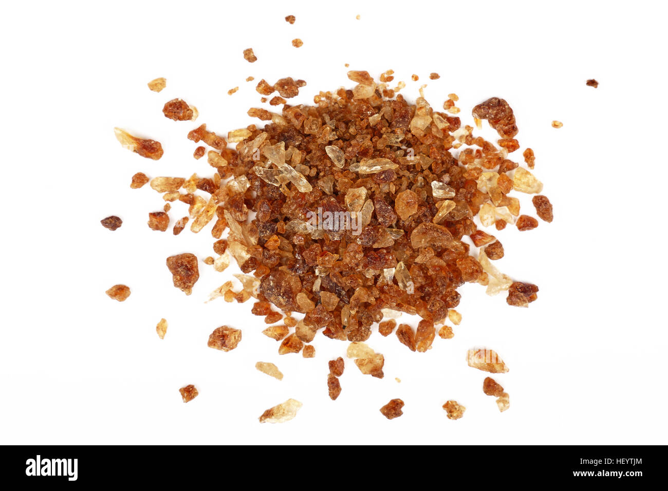 Pizzico di big brown caramella di cristalli di zucchero versato intorno isolato su sfondo bianco, close up, elevati vista superiore Foto Stock