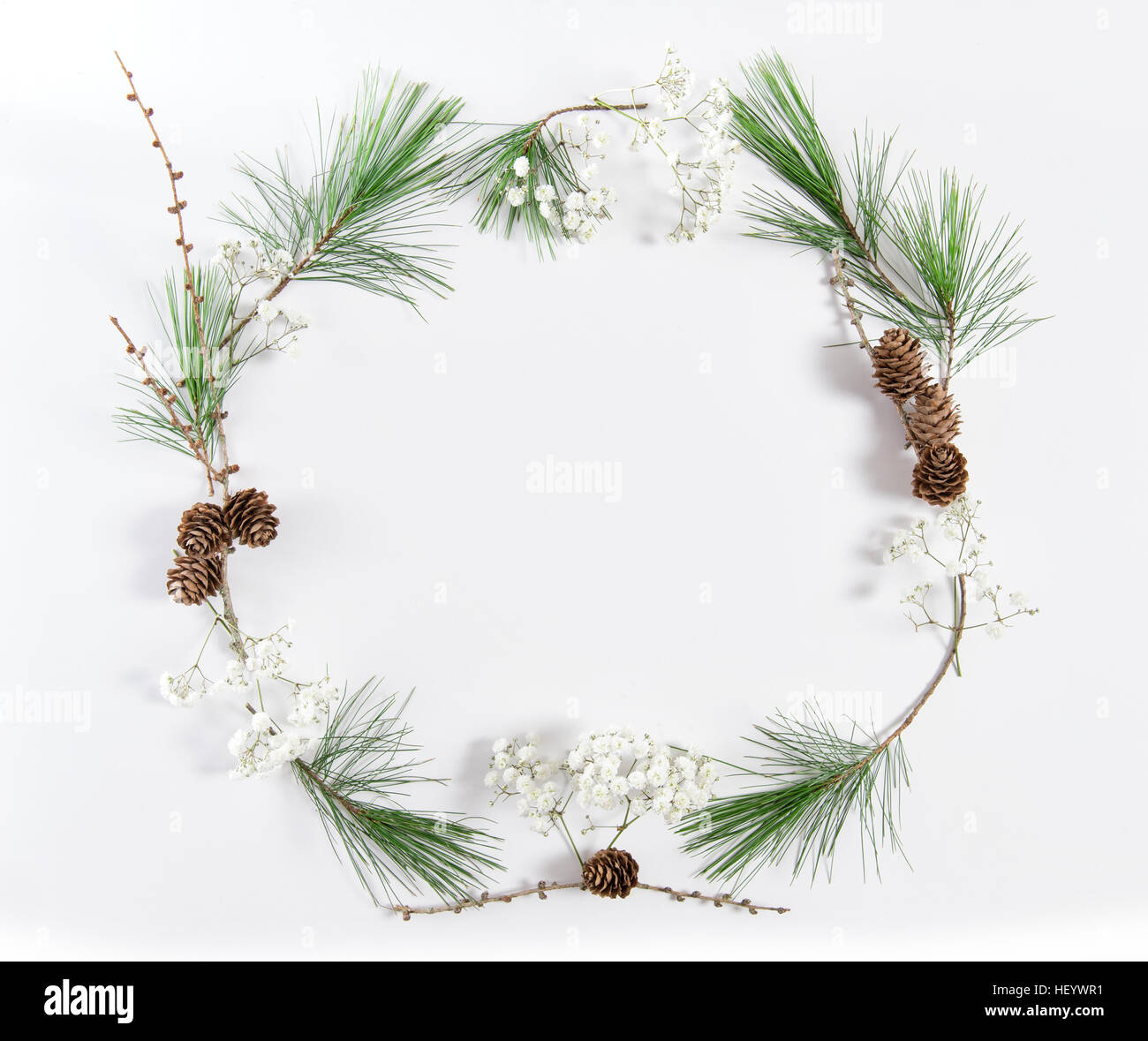 Il telaio dal pino rami con rocche su sfondo bianco. Vacanze di Natale lay piatto Foto Stock