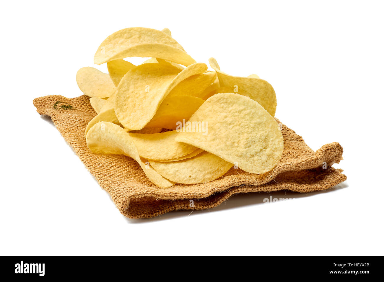 Cumulo di patatine sul tessuto di iuta su bianco Foto Stock