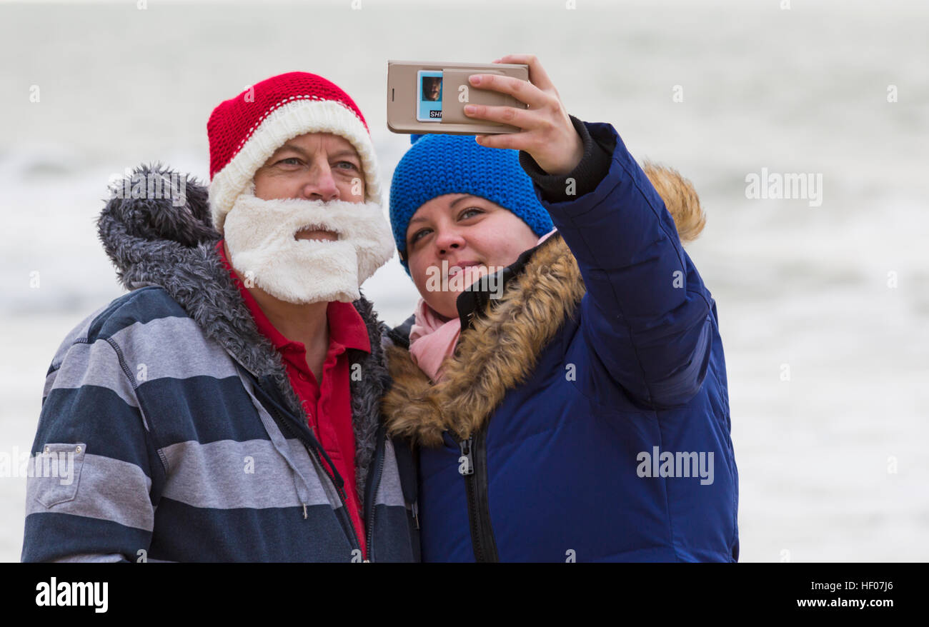 Bournemouth, Dorset, Regno Unito. 25 Dic 2016. Giorno di Natale 25 dicembre 2016. Tuffo bianco di Natale a Boscombe, Bournemouth, Dorset, Regno Unito. Coraggiosi volontari si tuffano nel freddo mare agitoso per una nuotata, per la nona nuotata annuale di Natale mattina, vestiti con costumi di fantasia e raccogliere soldi per Macmillan cura locale a Christchurch, una Specialist Palliative Care Unit per i pazienti nella comunità locale. Centinaia di persone partecipano all'evento che è diventato una tradizione popolare per molti prima del pranzo. © Carolyn Jenkins/Alamy Live News Foto Stock