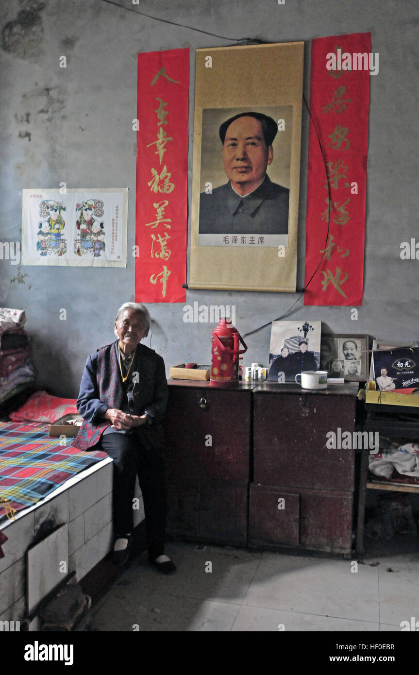 Yuncheng, Yuncheng, Cina. Il 26 dicembre, 2016. Yuncheng, Cina al 26 dicembre 2016: (solo uso editoriale. Cina OUT) .Qin Yuling, un 97-anno-vecchia donna, si siede nella sua casa decorata con il Presidente Mao Zedong il ritratto. È il 123º anniversario del Presidente Mao Zedong il compleanno su dicembre 26th, 2016. Il presidente Mao Zedong il ritratto può essere visto in molti cinesi la vita quotidiana delle persone. © SIPA Asia/ZUMA filo/Alamy Live News Foto Stock