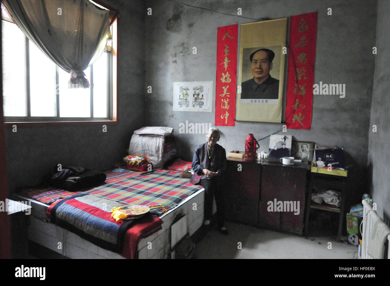 Yuncheng, Yuncheng, Cina. Il 26 dicembre, 2016. Yuncheng, Cina al 26 dicembre 2016: (solo uso editoriale. Cina OUT) .Qin Yuling, un 97-anno-vecchia donna, si siede nella sua casa decorata con il Presidente Mao Zedong il ritratto. È il 123º anniversario del Presidente Mao Zedong il compleanno su dicembre 26th, 2016. Il presidente Mao Zedong il ritratto può essere visto in molti cinesi la vita quotidiana delle persone. © SIPA Asia/ZUMA filo/Alamy Live News Foto Stock
