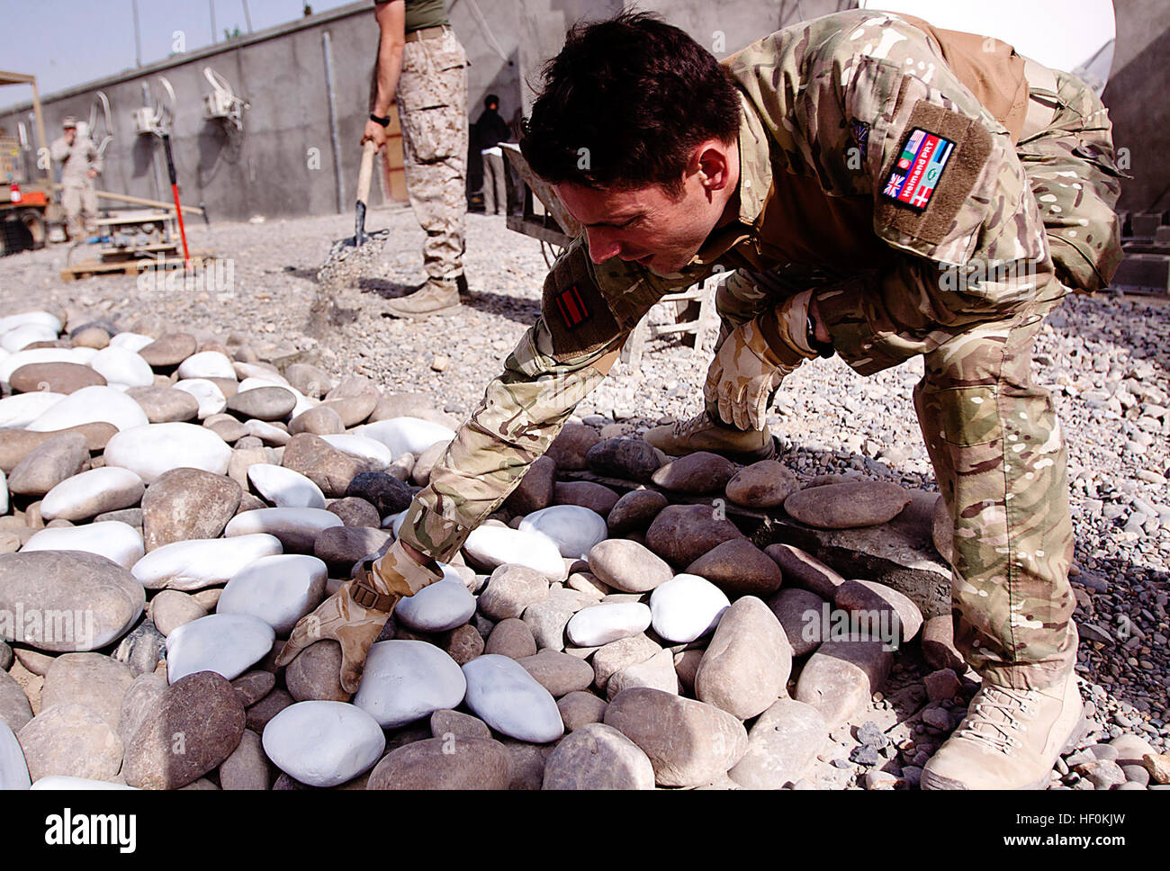 Un membro del servizio dell'esercito britannico lavora alla ristrutturazione del Forward Operating base Delhi Memorial, originariamente dedicato al personale che prestava servizio a Garmsir. La ricostruzione amplia il memoriale per onorare le forze britanniche, afghane e marine, con miglioramenti strutturali e ulteriori flagpole aggiunti prima della cerimonia del Remembrance Day. Foto Stock