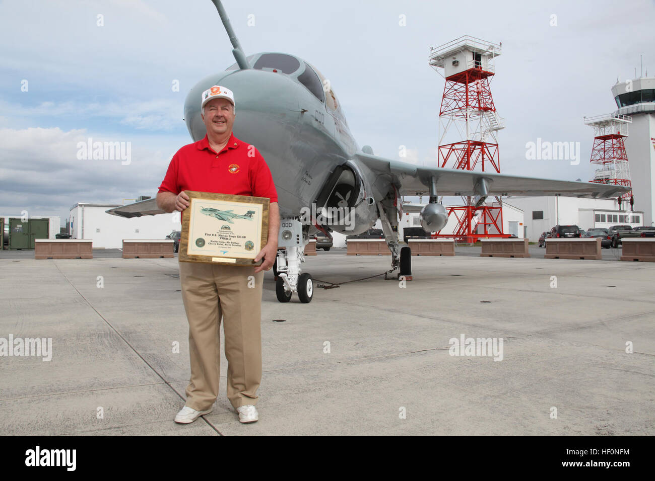 Il colonnello in pensione Wayne Whitten detiene una lapide che ricorda la consegna del primo EA-6B Prowler a MCAS Cherry Point, che ha avuto luogo nel febbraio 17, 1977. Whitten era un membro dell'equipaggio che ha consegnato il velivolo qui 35 anni fa. Il Prowler dietro di lui è la stessa che aveva espresso al punto di ciliegia e il solo EA-6B a mai servire in una marina electronic warfare squadron. Malintenzionati celebrare 35 anni di servizio 120217-M-AF823-016 Foto Stock