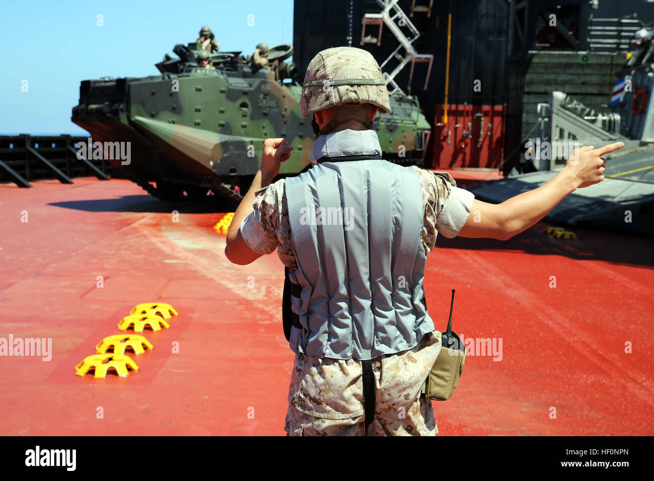 Un marine con sede a reggimento, 1° Marine Logistics Group, massa-guide un assalto anfibio spegnere il veicolo una Landing Craft Air Cushion sulla USNS Montford Point, un mobile piattaforma di atterraggio, durante la prova di una capacità di seabasing, Luglio 9, 2014. Il programma MLP è un nuovo tipo di marittimi nave Pre-Positioning che facilita il trasferimento di attrezzature militari e personale da grandi navi a piccole landing craft. (U.S. Marine Corps foto di Sgt. Sarah Fiocco/RILASCIATO) 1° MLG prove nave-nave connettore 140709-M-AL626-8956 Foto Stock