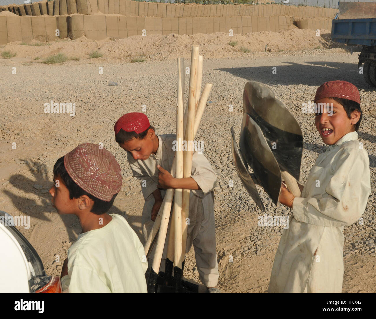 Locale ragazzi afghani provare a portare come molte pale come essi possono, Giugno 30, all'esterno, combattimento avamposto Kolk, Zharay distretto. Le pale sono uno dei tanti strumenti portati dagli uomini dal 445th gli affari civili e i loro partner afghani per riparare i bambini della scuola vicino a combattere avamposto Kolk. Gli affari civili i soldati di lavorano con gli abitanti di un villaggio per ricostruire la scuola 120630-Z-N327-105 Foto Stock