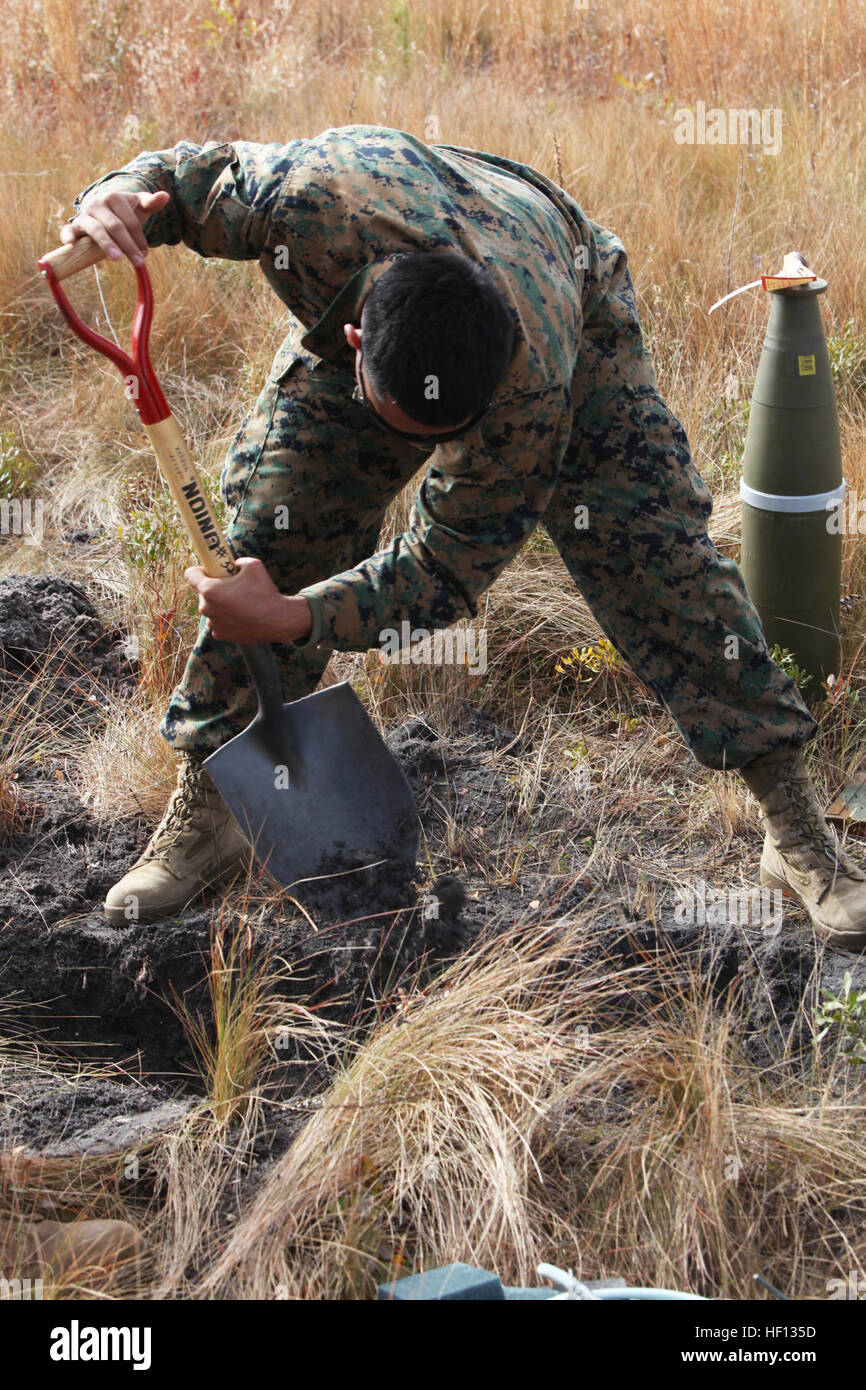 Un tecnico di munizioni con proiettili Company, 2° Battaglione di alimentazione, 2° Marine Logistics Group ritaglia un piccolo trench per obsoleto inesplosi durante l'unità di emergenza della formazione di demolizione a bordo di Camp Lejeune, N.C., Dicembre 4, 2012. Le pareti in terracotta della trincea ha contribuito a garantire gli esplosivi sono rimasti confinati in una piccola area della gamma e sono stati completamente distrutti dopo la detonazione. Munizioni Marines casa pulita durante la formazione di demolizione 121204-M-ZB219-064 Foto Stock