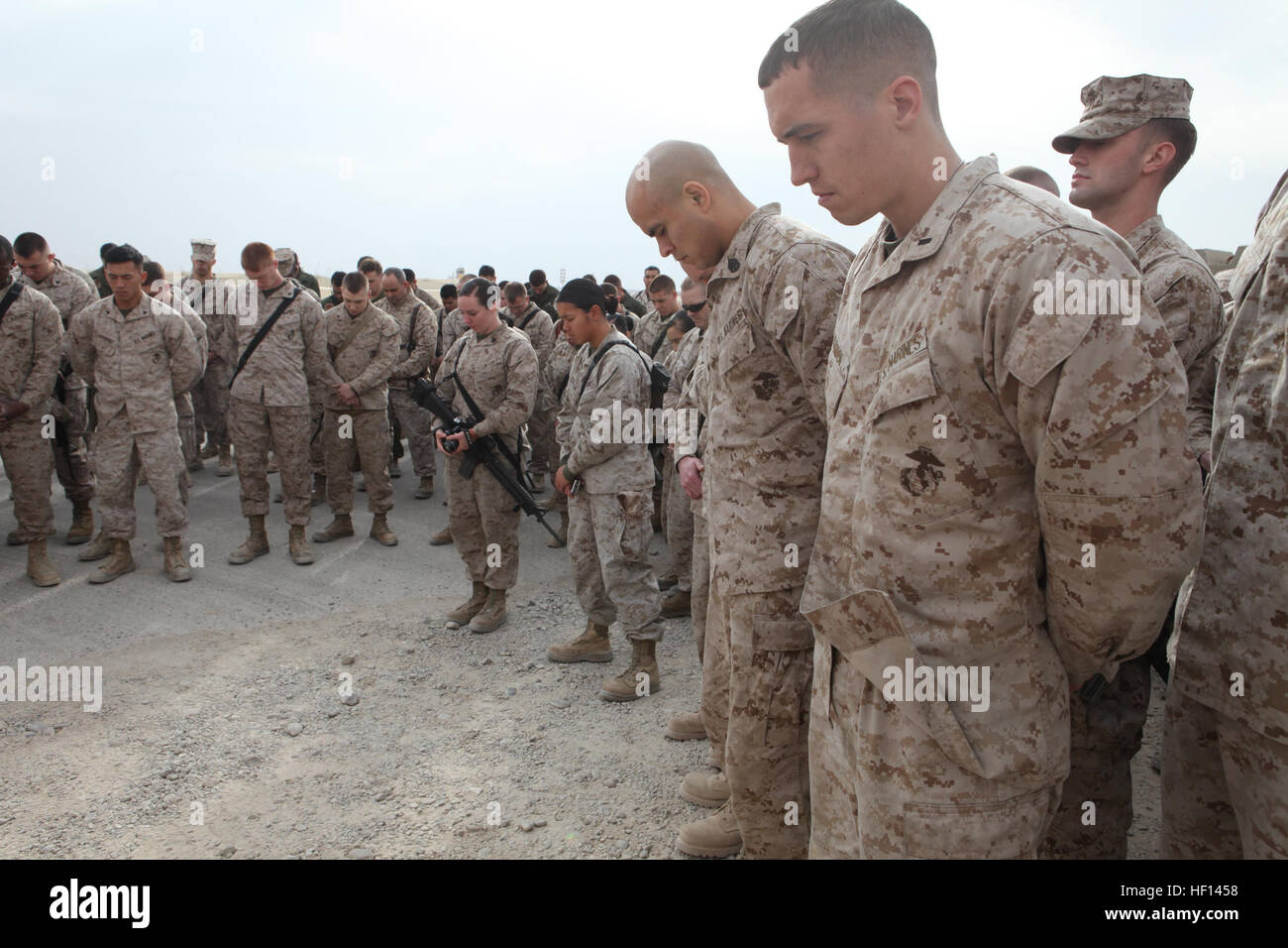 Stati Uniti Marines e marinai con Marine Aviation Logistics Squadron (MALS) 16, Marine Aircraft Group 16, terzo aeromobile Marina Wing (avanti), prua le loro teste in preghiera durante una dedizione a Camp Bastion, provincia di Helmand, Afghanistan, 10 gennaio, 2013. Malles-16 dedicato il loro composto al Marine Corps Sgt. Bradley W. Atwell, che è stato ucciso in azione durante l'attacco su Camp Bastion, Sett. 14, 2012. (U.S. Marine Corps foto di Sgt. Keonaona C. Paulo/RILASCIATO) Malles-16 dedica composto a Sgt. Atwell 130110-M-EF955-019 Foto Stock