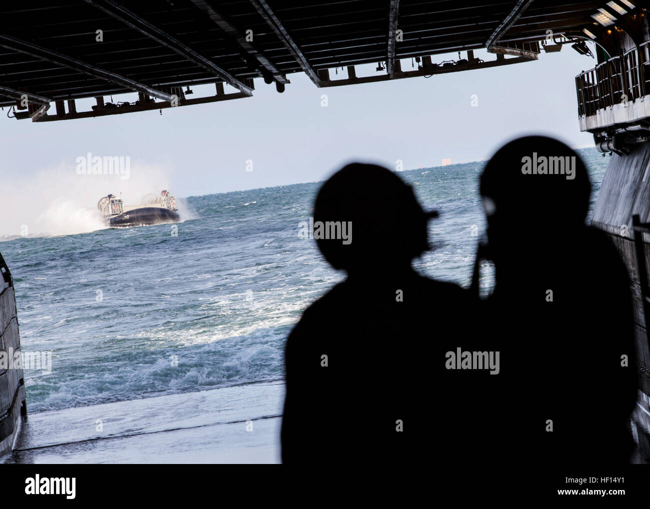 I marinai guarda come una landing craft, cuscino d'aria (LCAC) naviga verso il bene del ponte della USS Kearsarge (LHD 3), il 22 gennaio 2013. LCACs hanno la capacità di attraversare su acqua e terra dando la ventiseiesima Marine Expeditionary Unit (MEU) la capacità di ingranaggio di trasporto e truppe tra nave e terra. Il MEU e squadrone anfibio (PHIBRON) 4 sono in conduzione PHIBRON-MEU Integrazione in preparazione per la loro formazione composita dell'Unità Esercizio, la fase finale di sei mesi di pre-distribuzione programma di formazione. Il ventiseiesimo MEU funziona continuamente in tutto il mondo, fornendo il presidente e unified combata Foto Stock